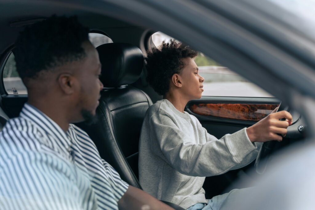 pexels-photo-9518015-9518015 A father teaches his son to drive, sitting together in a car and discussing techniques. Side view indoors.